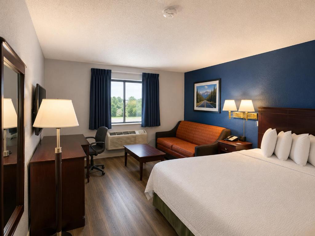 ein Hotelzimmer mit einem Bett und einem Stuhl in der Unterkunft Corning Inn in Painted Post