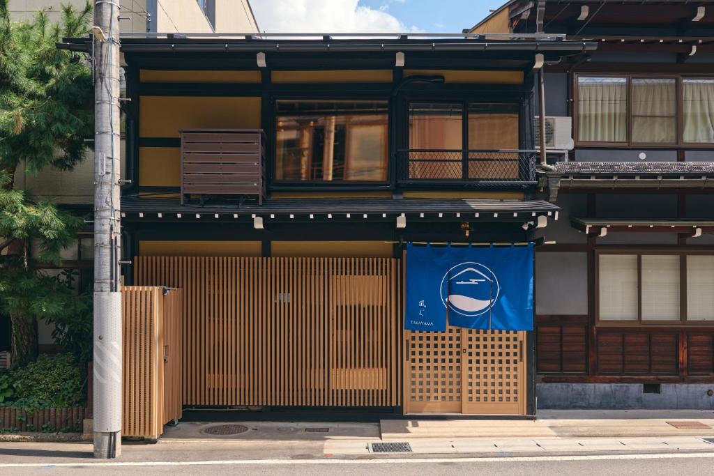 a building with a blue sign on the side of it at 御宿 凪ぐ Takayama in Takayama