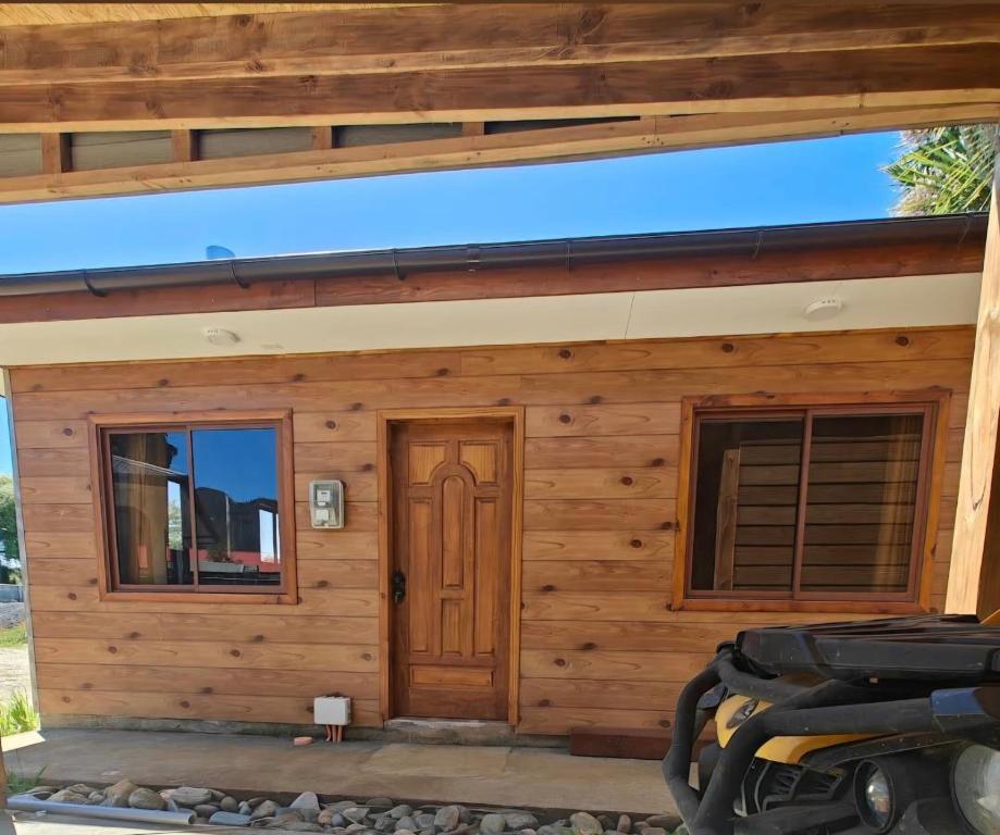 a log cabin with a door and windows at Cabaña Queule Costero in Queule