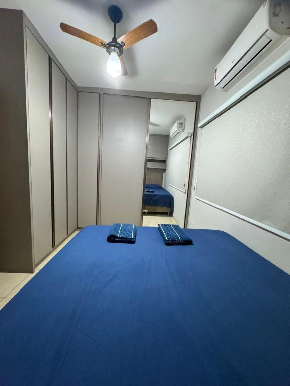 a room with a blue bed with two remote controls at Sobrado Azul in Várzea Grande