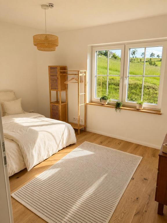 a bedroom with a bed and two windows and a rug at Landidylle in Wenden Schönau in Wenden
