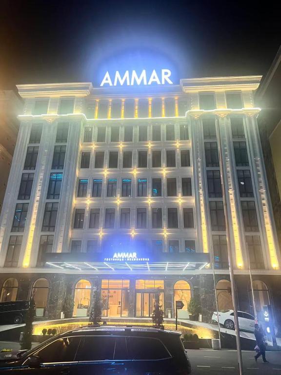 a amrar building with a car parked in front of it at Ammar Hotel in Dushanbe