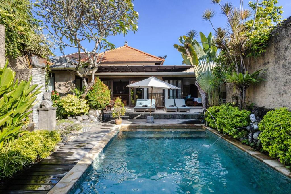 a swimming pool in the backyard of a house at Villa Nesanur - Comfortable & Spacious Beachside Sanur in Sanur