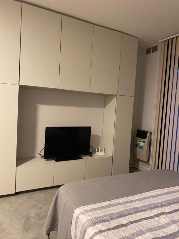 a bedroom with a tv on a white cabinet at Monoambiente céntrico in Gualeguaychú