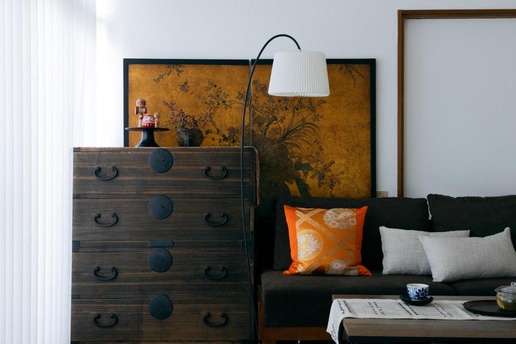 a living room with a green couch and a dresser at 青梅駅3分OME桜梅庵omean tinyhouse designers hideaway in Ome