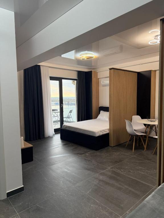 a bedroom with a bed and a table and chairs at Luxury & Spacious Studio - Navodari in Năvodari