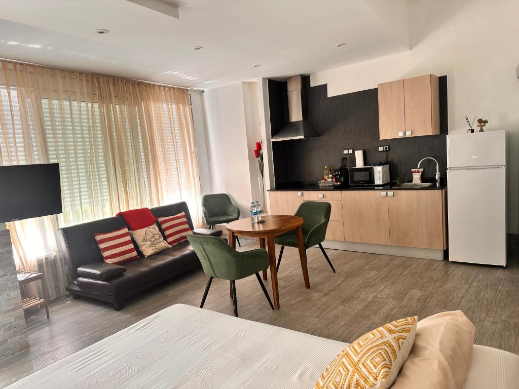a living room with a couch and a table and a kitchen at Apartaments IRI in Pineda de Mar