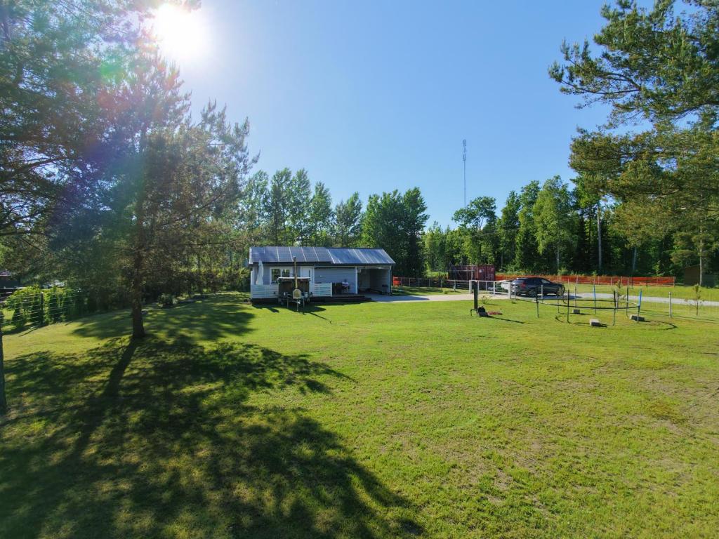 a large grassy field with a shed in the background at Kril in Remniku