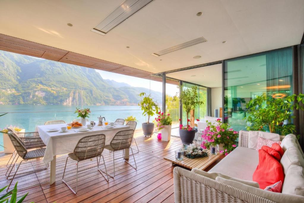 a dining room with a view of the water at Maison Sur l'Eau - Lugano Villa with View Terrace in Paradiso