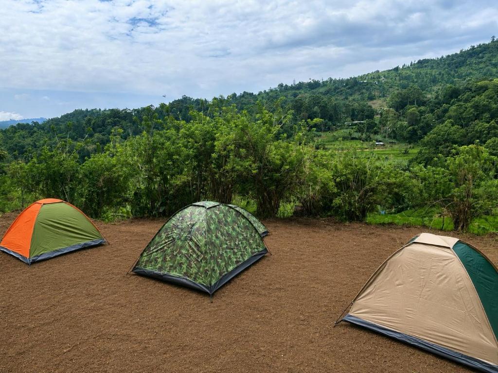 three tents on a dirt field with trees in the background at Eco Camping Resort Ella in Bandarawela