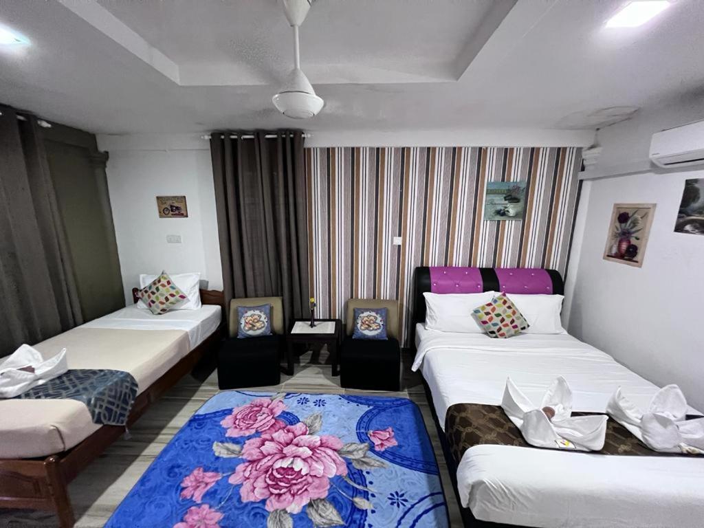 a hotel room with three beds and a table at Asni chalet in Marang