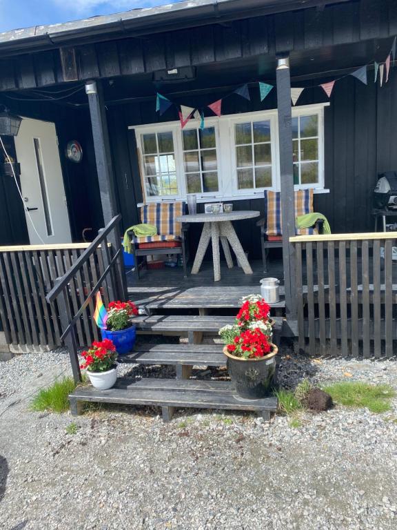 a porch of a house with a picnic table and flowers at Golsfjellet in Gol