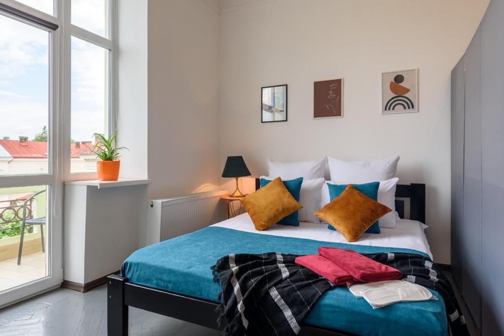 a bedroom with a bed and a large window at Студія біля Університету in Chernivtsi