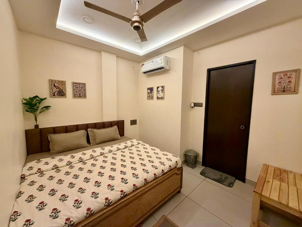 a bedroom with a bed and a ceiling fan at Yatha sukham Prutham in Ujjain