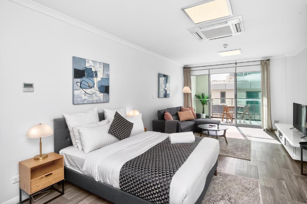 a bedroom with a bed and a living room at 188 Apartments in Perth