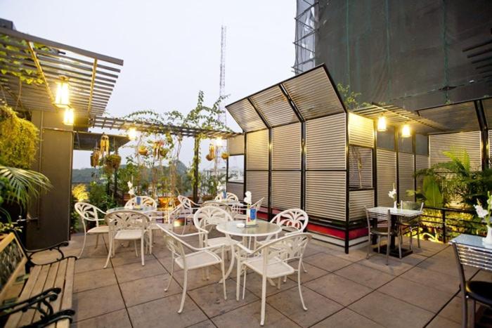 a patio with white chairs and tables on a building at Well Park Residence in Chittagong