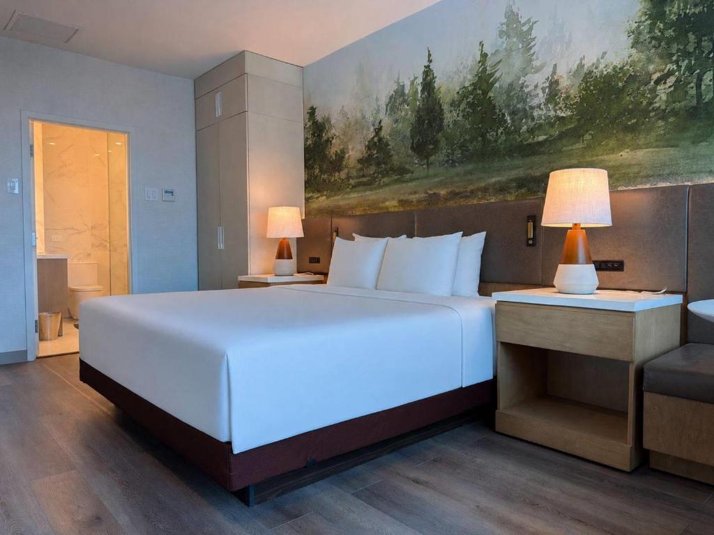 a bedroom with a large white bed and a couch at Radisson Hotel Trinidad in Port-of-Spain