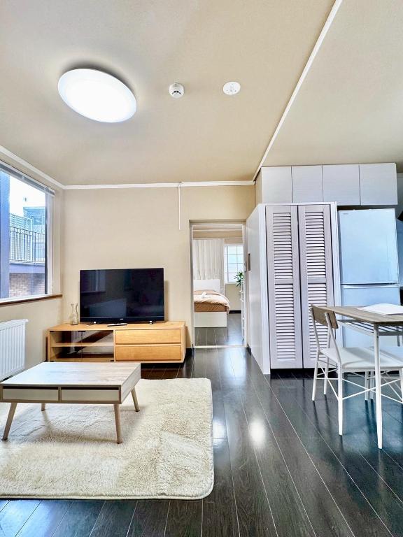 a living room with a table and a tv at 北海道大学ENYA-n17 in Sapporo