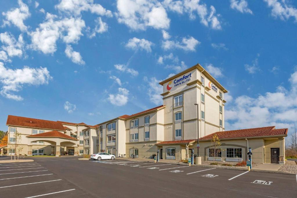 a hotel with a car parked in front of a parking lot at Comfort Inn & Suites Verona at Turning Stone Resort Casino in Verona