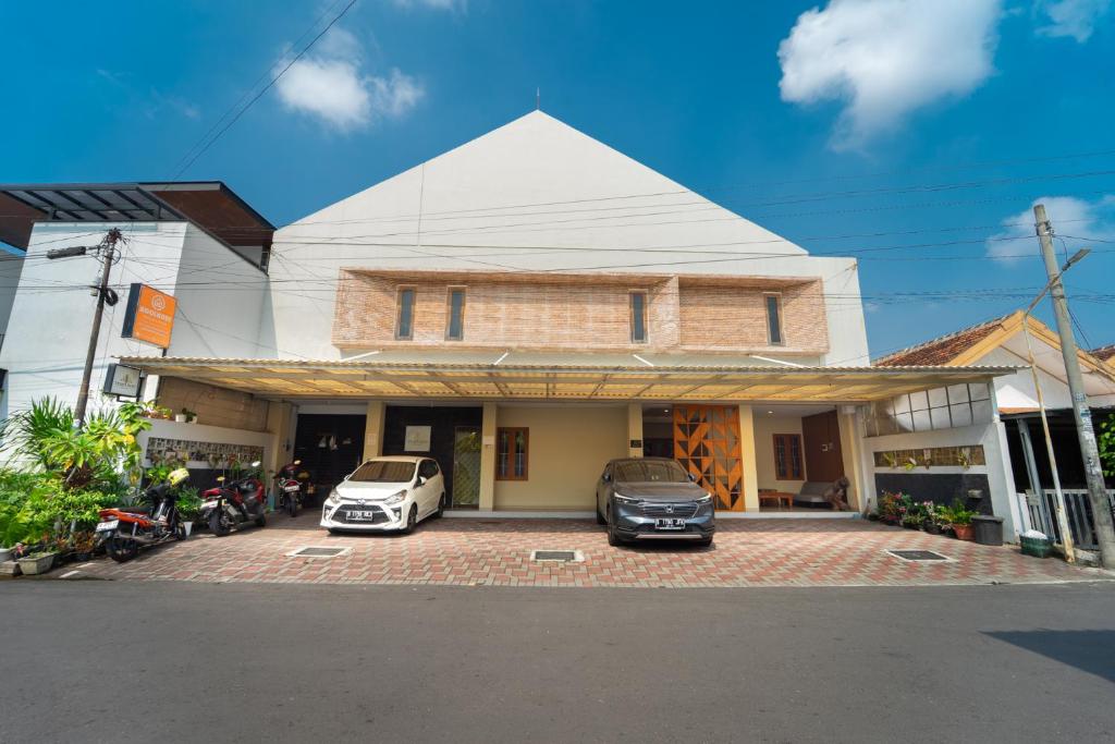 two cars parked in front of a house at Tempuran Suites By ARBA in Kejayan