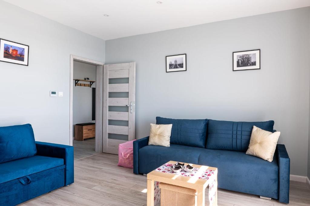 a living room with a blue couch and a table at Apartament 16 in Sandomierz