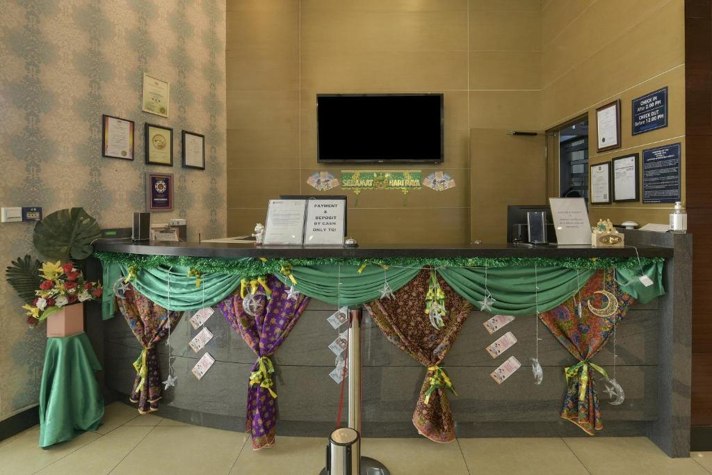 A compact reception desk decorated with colorful draped textiles.