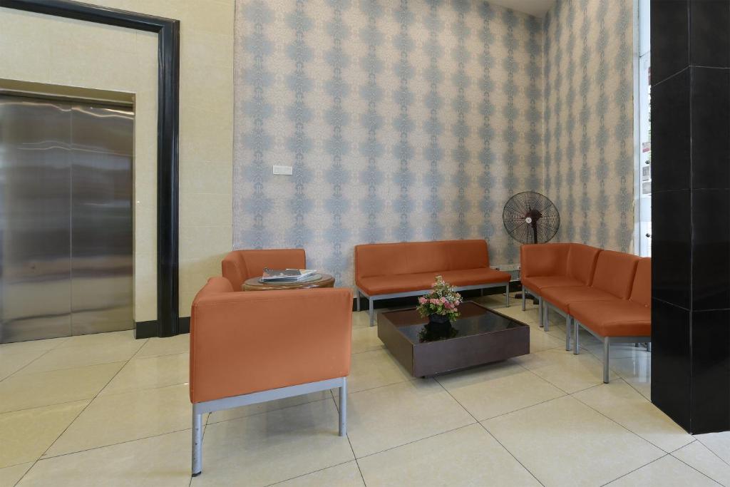 A compact waiting area offers orange upholstered seating around a low central table.