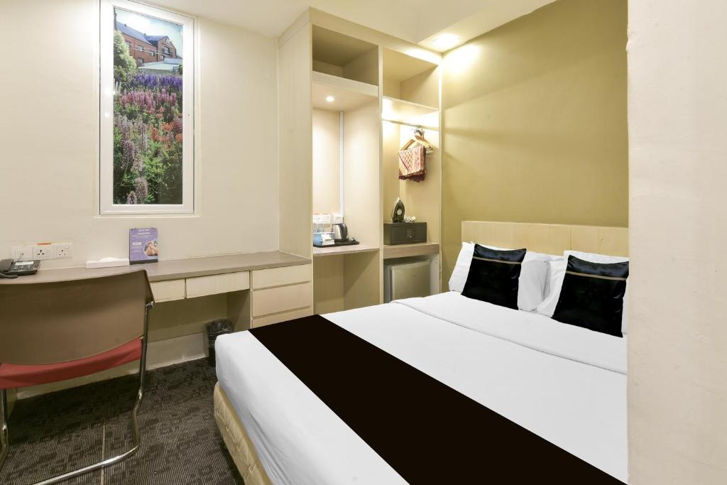 A compact guest room with a double bed, built-in storage and a small desk.