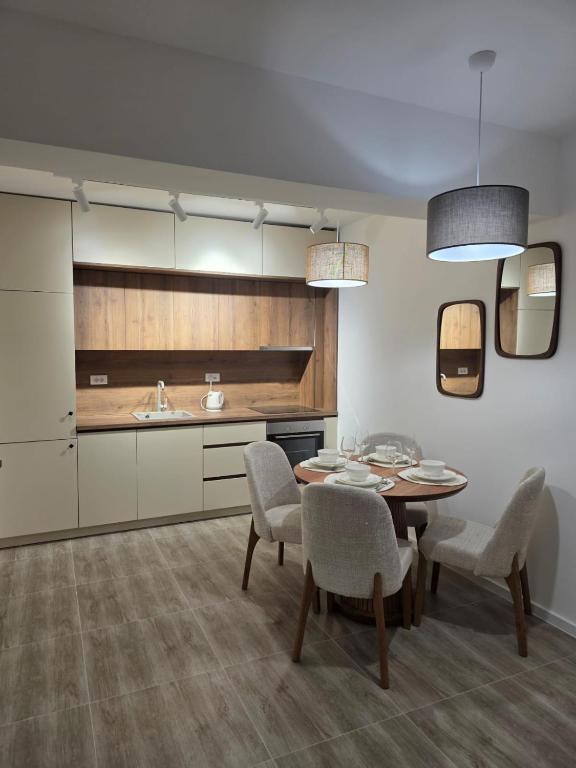 a kitchen with a dining room table and chairs at A&A Apartment in Šušanj