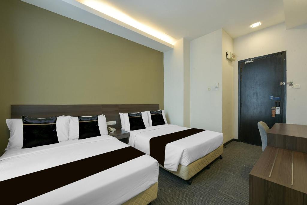 A two-bed guest room with a small desk beside the entrance.