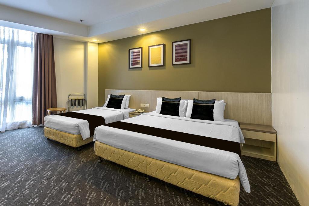 A larger room with two beds, an additional single bed and a curtained window.