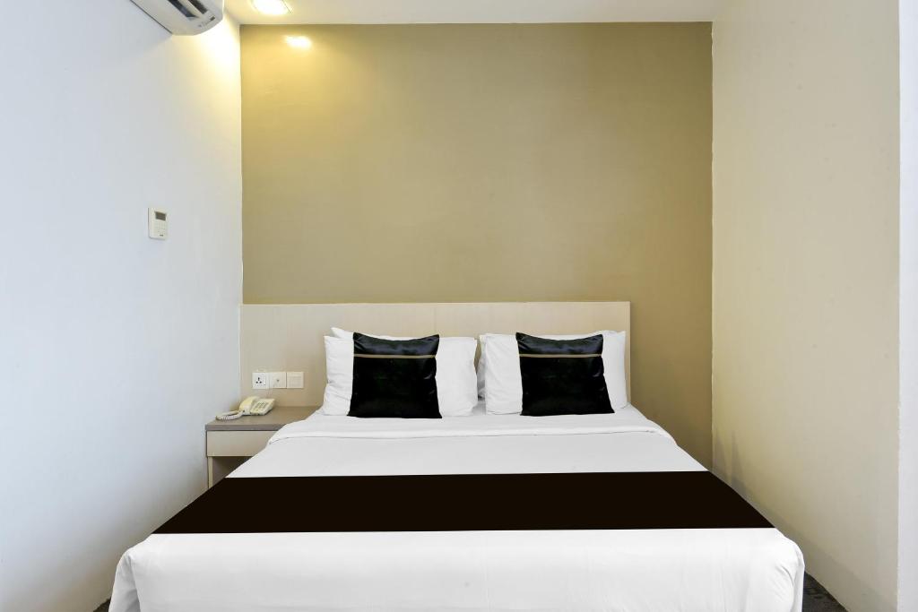 A double room with a large bed, bedside telephone and wall-mounted air conditioner.