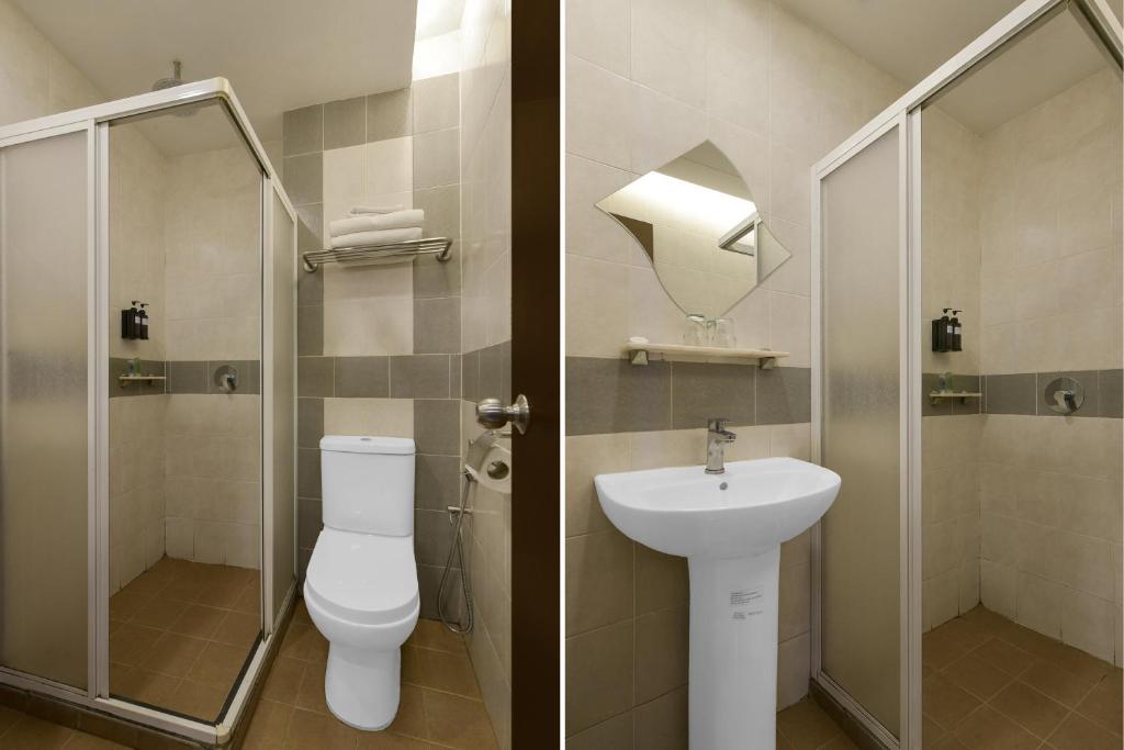 A compact tiled bathroom with a glass shower enclosure, toilet and pedestal sink.