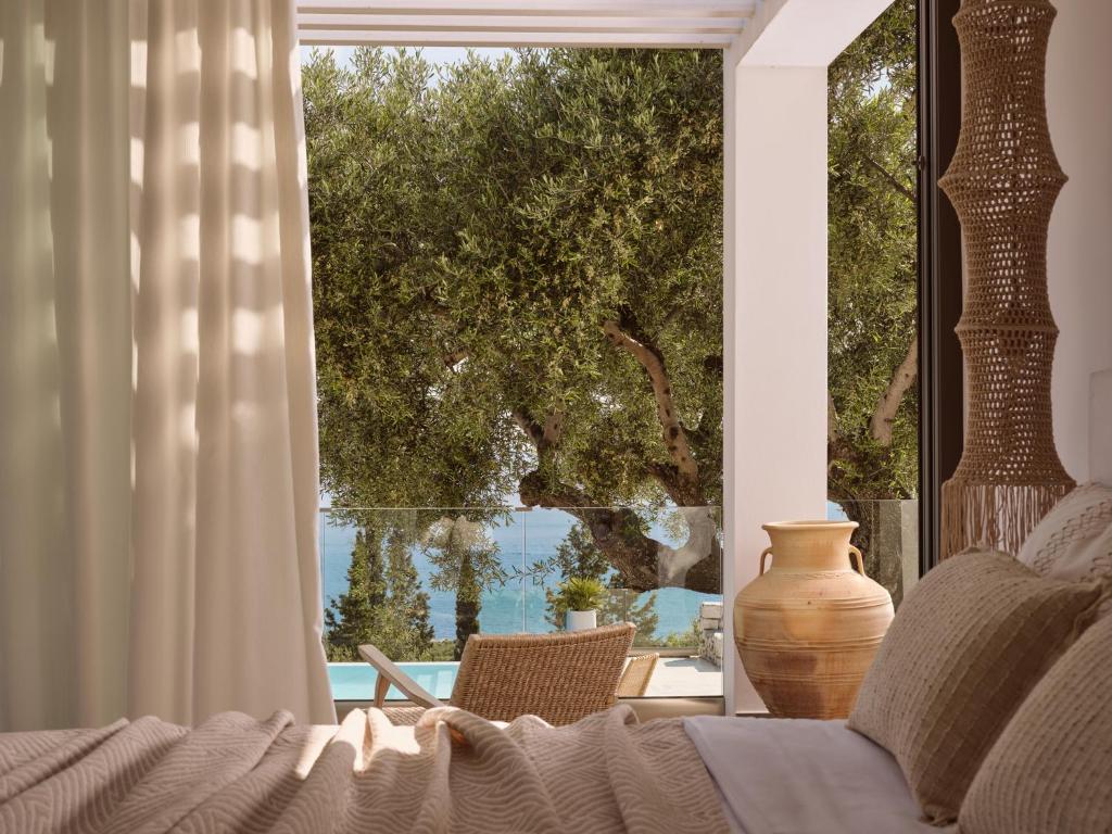 a bedroom with a large window with a vase and a couch at PanoPlagia Villa in Agios Nikolaos