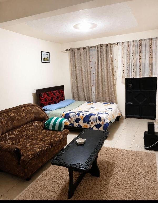 a living room with a couch and a bed at Limuru stays in Ngecha