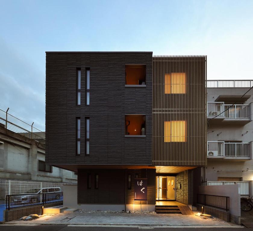 a tall black building with its front entrance at はく HIROSHIMA Station HOTEL in Hiroshima