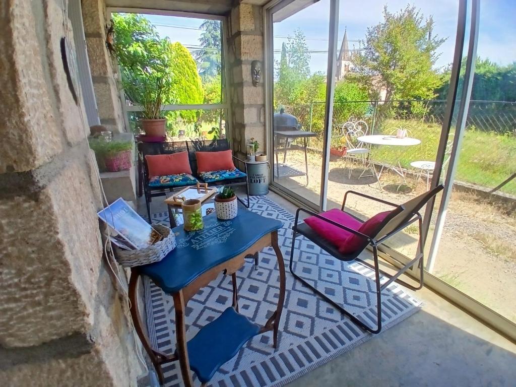 a patio with a table and chairs on a balcony at Chez Lulu Grand Studio Cote Jardin avec Veranda in Saint-Sernin