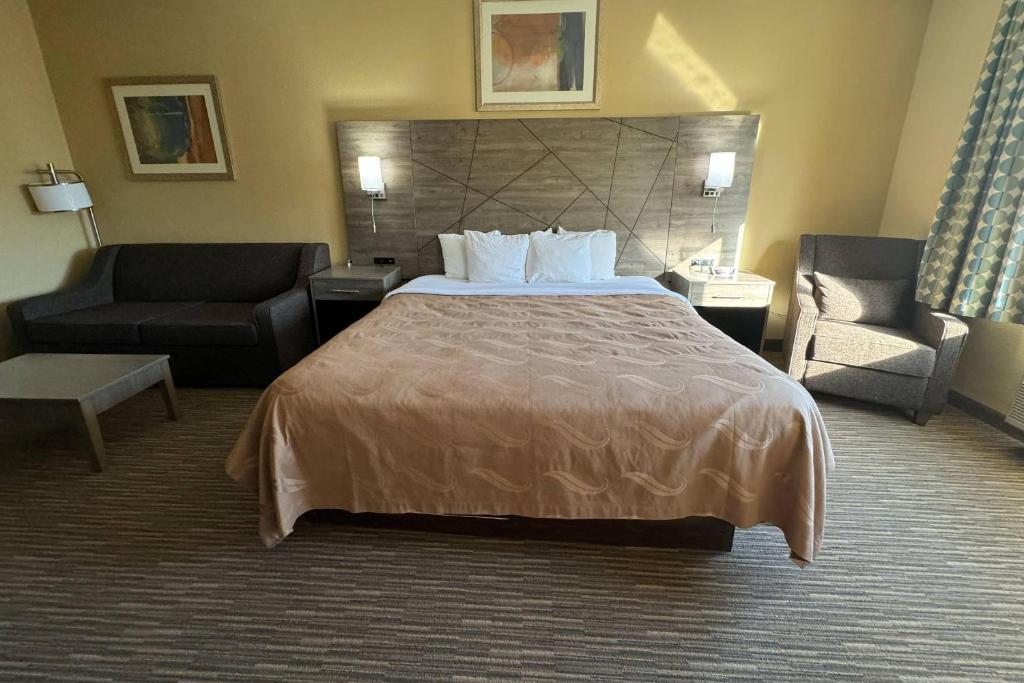 a hotel room with a bed and a chair at Quality Inn Forsyth Decatur in Forsyth