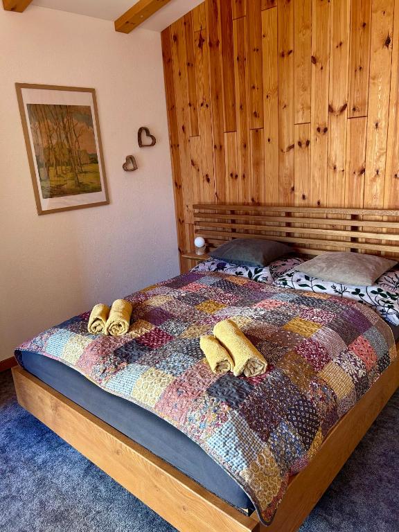 a bedroom with a bed with a wooden wall at Villa Montis in Vysoké Tatry