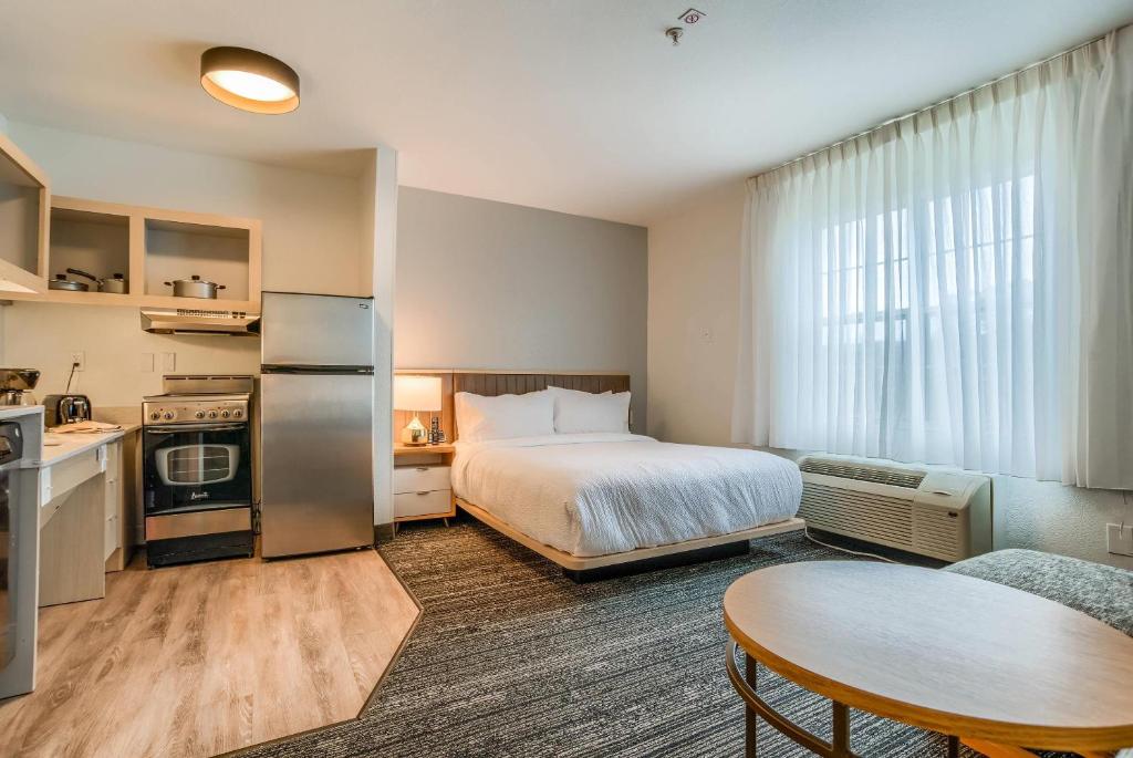 a hotel room with a bed and a table and a kitchen at MainStay Suites in Mobile