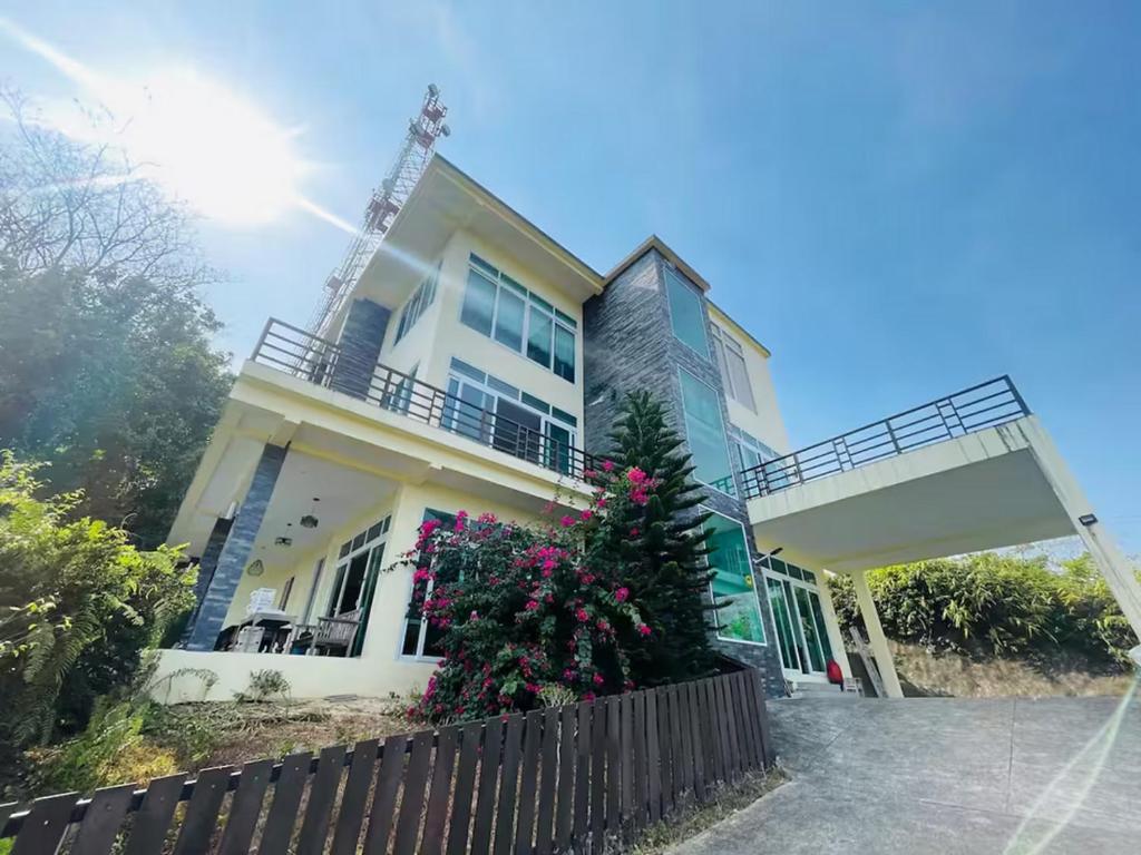 a white house with a fence in front of it at Sea View Luxury Mansion, Pool & Jacuzzi - Koh Chang in Ko Chang