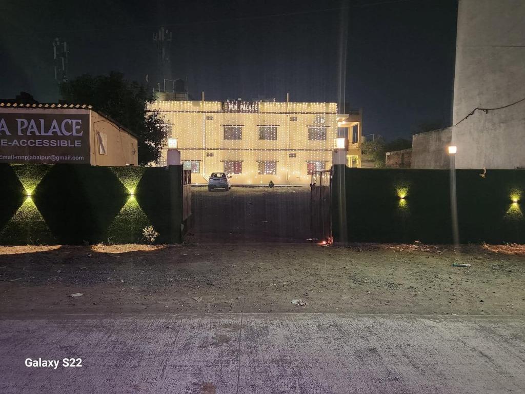 a fence with a building in the background at night at Hotel MNP in Jabalpur