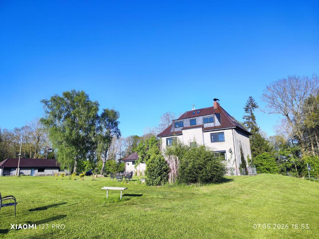 a large white house on a green field at Chalets in nature Nedderhagen in Damshagen