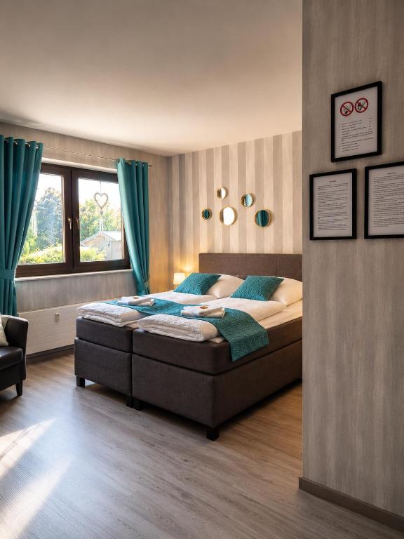 a bedroom with a bed with blue pillows and a window at Luxsuite Studio Oberhausen Centro Bahnhof in Oberhausen