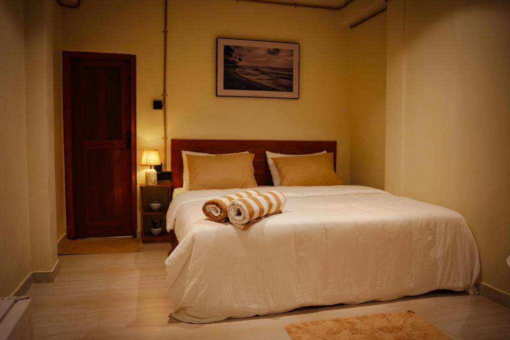 a bedroom with a bed with white sheets and pillows at Mi Casa Coastal Villa in Akurala