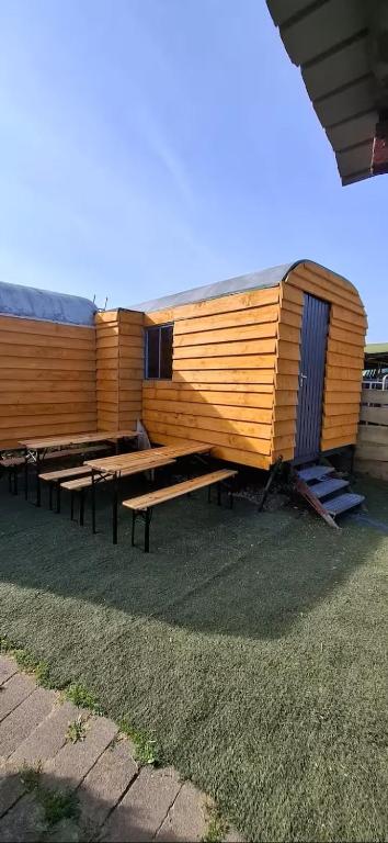 a group of picnic tables in front of a building at Tiny House auf der Kingswood Ranch in Cornberg