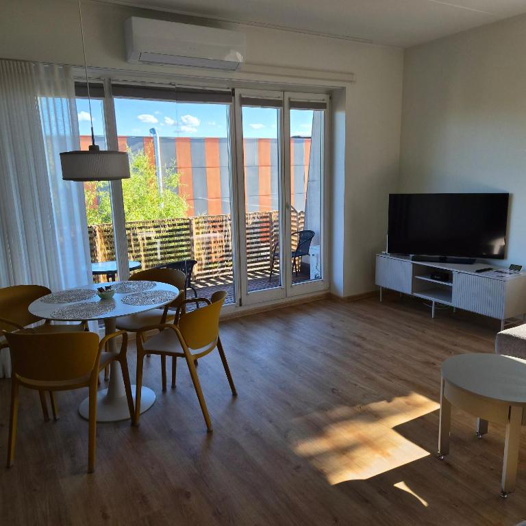 a living room with a table and chairs and a television at Kastani Home 15 in Tartu