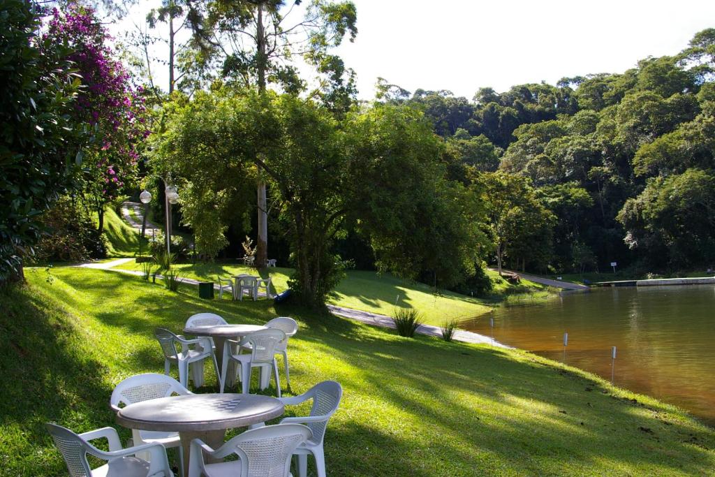 a row of tables and chairs next to a river at Pousada e Marina Pier 44 in Nazaré Paulista