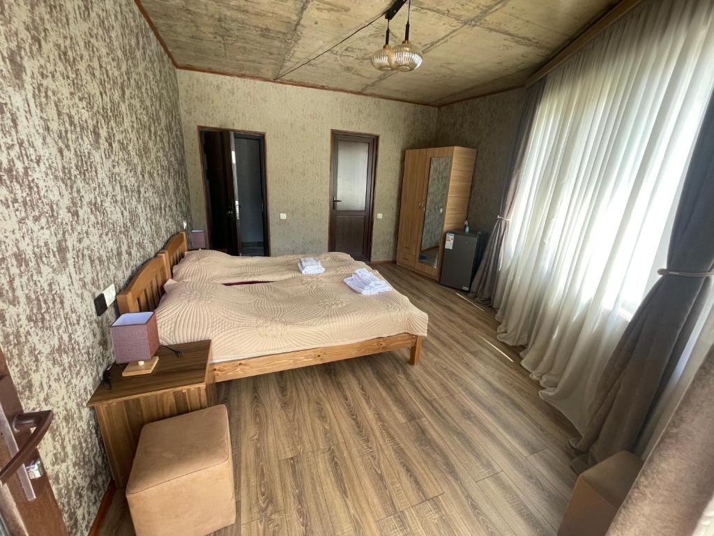 a bedroom with a bed and a desk and a window at Muros Guesthouse in Mestia
