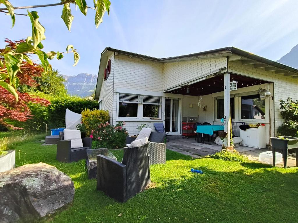 a house with chairs and a table in the yard at Flumserberg pur, Auszeit am Walensee in Flums